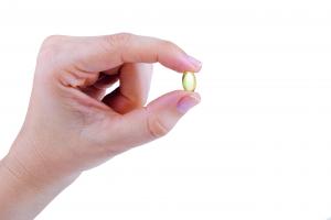 Hand holding fish oil supplement