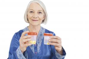 Elderly senior woman holding medicine bottles