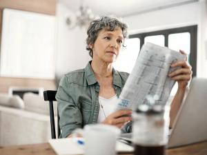 Mature woman reading newspaper