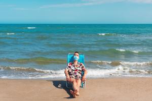 Man relaxing on a beach with mask