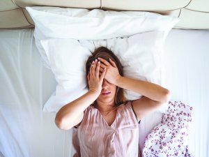 hands on head lying in bed