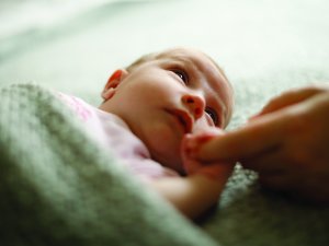 Baby holding mum's finger